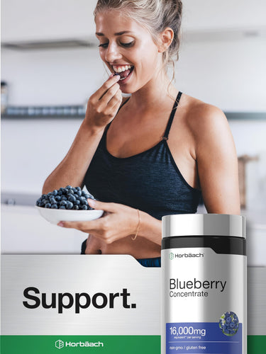 View 6 A young woman eating blueberries from a bowl next to a blueberry supplement bottle.