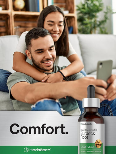 Couple sitting on a couch using a smartphone with a bottle of Horbaach Burdock Root Liquid Extract in the foreground.