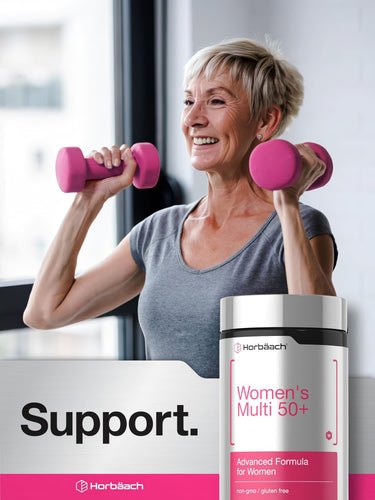 View 6 An older woman smiles while lifting dumbbells, with a Women's Multi 50+ supplement bottle nearby.