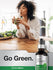 Woman drinking green juice with a bottle of Horbaach Liquid Chlorophyll on a kitchen counter.