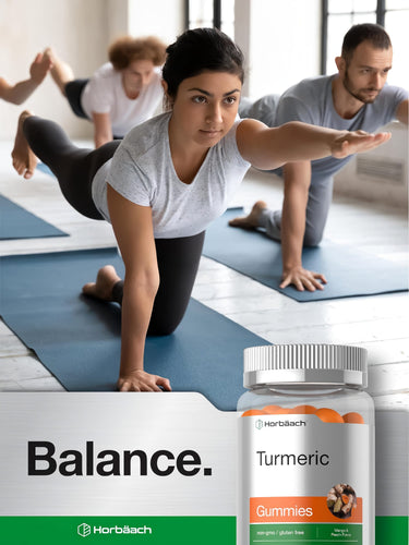 View 6 A young woman and man perform a balance exercise in yoga with a bottle of Turmeric Gummies nearby.