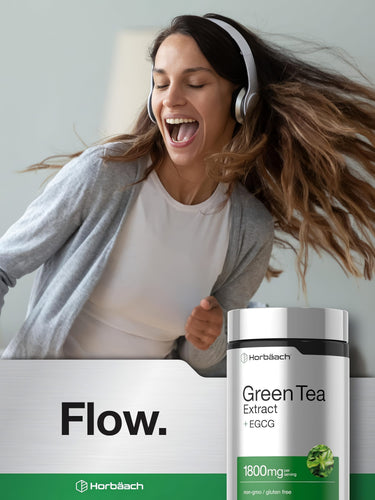 View 6 Woman joyfully dancing and singing with headphones beside a Horbäach Green Tea Extract + EGCG bottle.