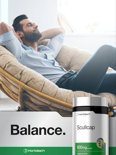 View 6 Adult man relaxes in a rattan chair with eyes closed, holding a Horbäach Scullcap supplement bottle.