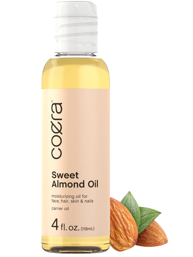 View 1 Coera Sweet Almond Oil bottle with almonds and leaves on a white background