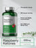 Bottle of Raspberry Ketones supplement with label details on a light gray background