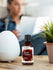 Bottle of Sweet Tobacco fragrance oil on a table with a diffuser and plant in the background.