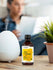view 4 Nag Champa fragrance oil bottle on a table with a person and plant in the background.