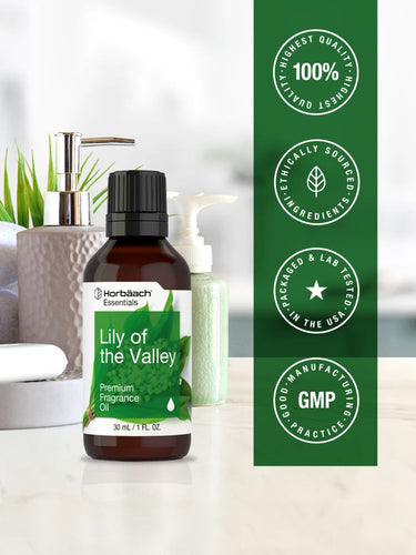 Bottle of Lily of the Valley premium fragrance oil with branding and quality assurance logos on a blurred background.