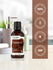 Coconut fragrance oil bottle with branding and certification logos on a blurred background