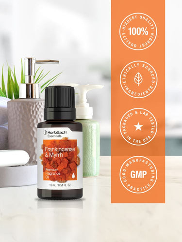 Herbals essentials frankincense and myrrh oil bottle with certification badges on an orange background