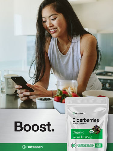 View 5 Woman using a phone in a kitchen with a Horbach elderberries package in the foreground.
