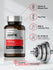 Bottle of AMPK Activator supplement with fitness weight bar on gray background.