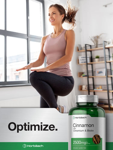 View 6 Woman exercising in a bright room with a bottle of supplements labeled 'Cinnamon with Chromium & Biotin'.
