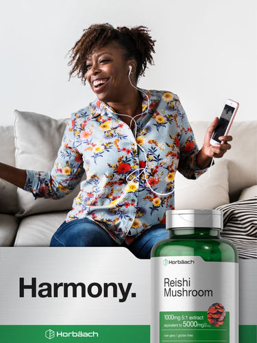 Woman sitting on a couch using a smartphone with a bottle of Reishi Mushroom supplement in front of her.