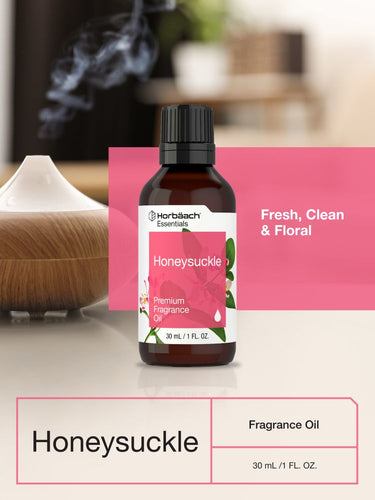 Honeysuckle fragrance oil bottle with pink label on a blurred background