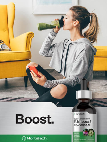 View 6 Woman drinking a green smoothie with a bottle of Horbaach Echinacea & Goldenseal supplement in a modern living room.