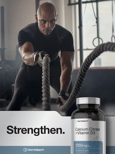 View 6 Man pulling a rope in a gym with a bottle of Horbaach Calcium Citrate + Vitamin D3 supplement.