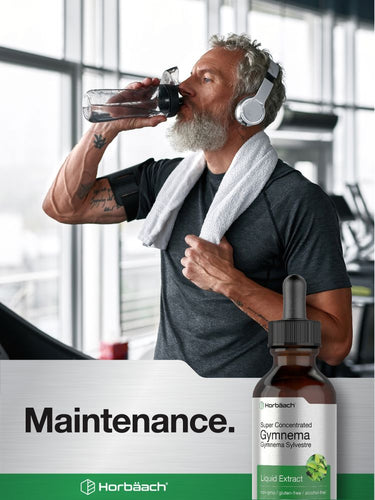 Man drinking from a glass with gym equipment in the background, Horbaach Gymnema supplement bottle on the side.