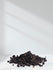 Pile of black peppercorns on a white background