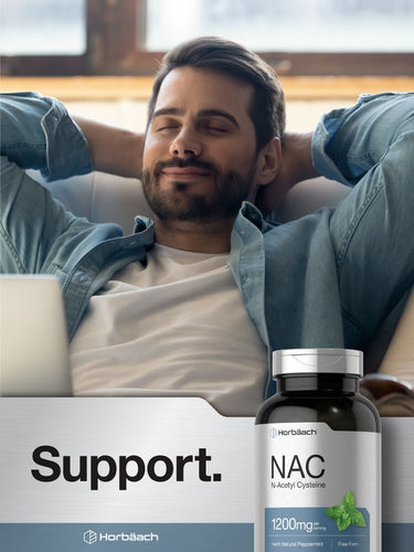 View 6 Man relaxing on a couch with a laptop, bottle of NAC supplement in the foreground.