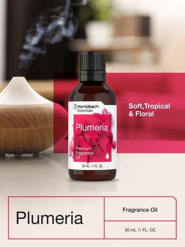 View 6 Bottle of Plumeria fragrance oil with a diffuser in a blurred background.