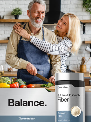 View 3 Older couple smiling and preparing food in a kitchen with a bottle of Horbäach Soluble & Insoluble Fiber on the counter.