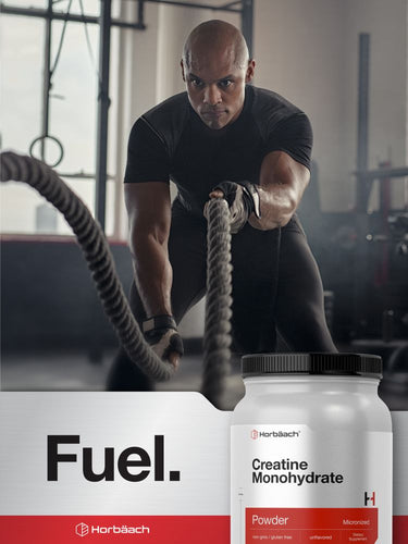 View 6 Man pulling ropes in a gym with Horbach Creatine Monohydrate Powder containers displayed.