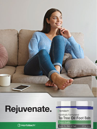 Woman relaxing on a couch with a bottle of Hertélach Tea Tree Oil Foot Balm in the foreground.