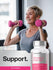 view 6 Woman exercising with pink dumbbells and a bottle of Women's Multi 60+ supplement.