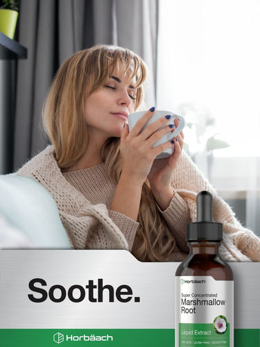 Woman holding a mug with a bottle of Horbaach marshmallow root extract on a white background