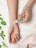 Person applying peppermint oil to wrist with mint leaves on white background