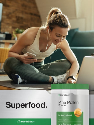 Woman using a laptop with a container of Horbäck Pine Pollen Powder in the foreground.