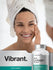 Woman with towel on head smiling next to Multi Collagen Protein bottles.