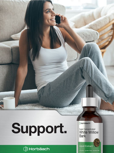 Woman sitting on a couch with a bottle of Horbaach white willow bark liquid extract.