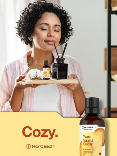 View 7 Woman holding a tray with essential oil bottles and a bottle of warm vanilla sugar on a yellow background.
