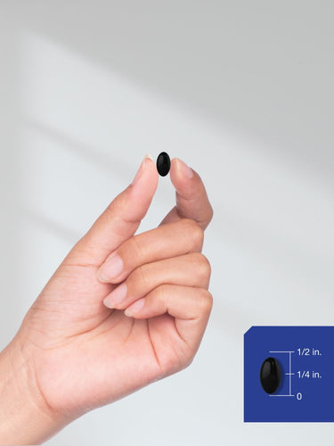Hand holding a small black object with a measurement inset on a light gray background