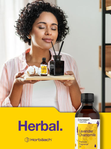 View 7 Woman holding a tray with essential oil bottles and a bottle of lavender chamomile oil on a yellow background.