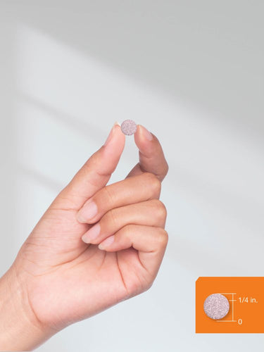 Hand holding a small pink tablet with a plain background