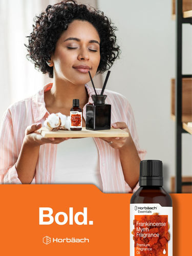 View 10 Woman holding a tray with fragrance bottles and diffuser, Horbaach Frankincense Myrrh Fragrance bottle displayed below.