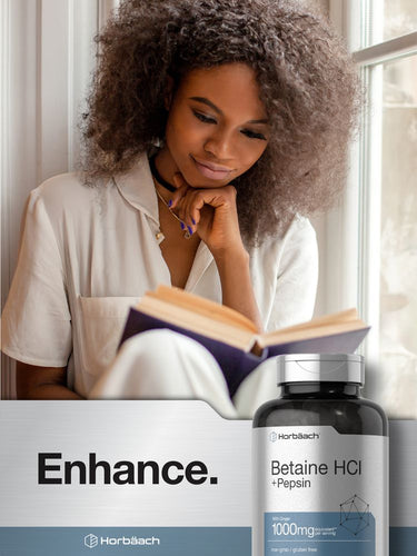 Person reading a book with a bottle of Betaine HCl + Pepsin in the foreground.