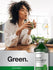 Person drinking green juice with a bottle of liquid chlorophyll in the foreground.