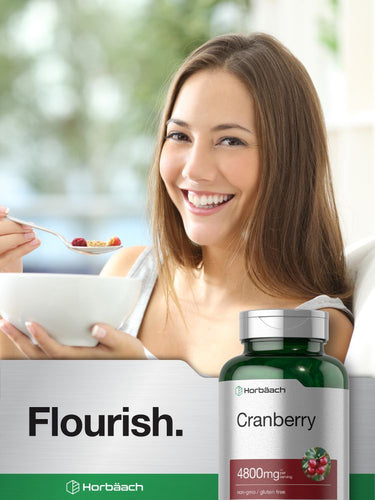Woman having cereal with a bottle of Cranberry supplement in the foreground.