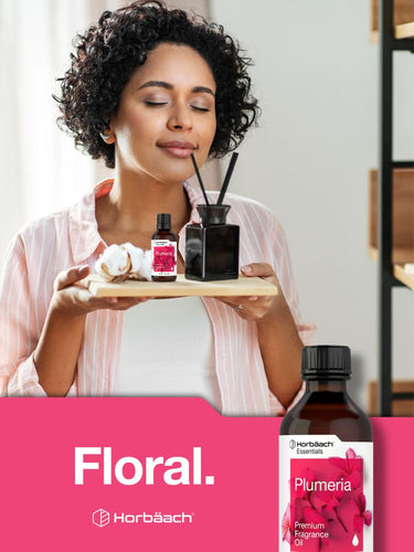 View 7 Woman holding a tray with fragrance bottles and a pink 'Floral' label on a white background.