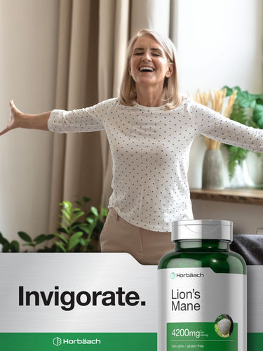 View 7 Woman smiling with arms outstretched, bottle of Lion's Mane supplement in foreground.