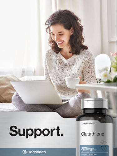 Woman using a laptop with a cup of coffee, Horbaach Glutathione supplement bottle in the foreground.
