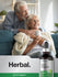 Senior couple smiling at home with a bottle of oil of oregano in the foreground.