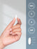 Hand holding a white pill with certification icons on a light gray background