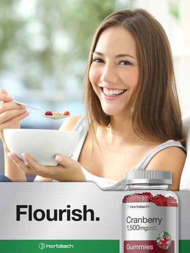 View 7 Woman enjoying a bowl of cereal with a bottle of Cranberry gummies in the foreground.
