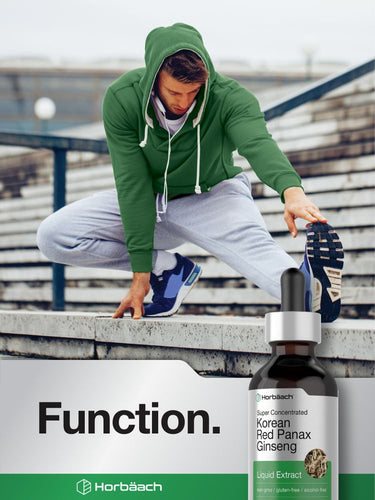 View 7 Person in green hoodie and gray pants sitting on a bench with a bottle of Korean Red Panax Ginseng extract.