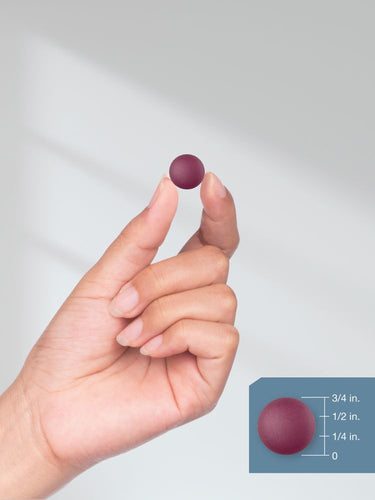 Hand holding a small purple object with a size measurement inset.